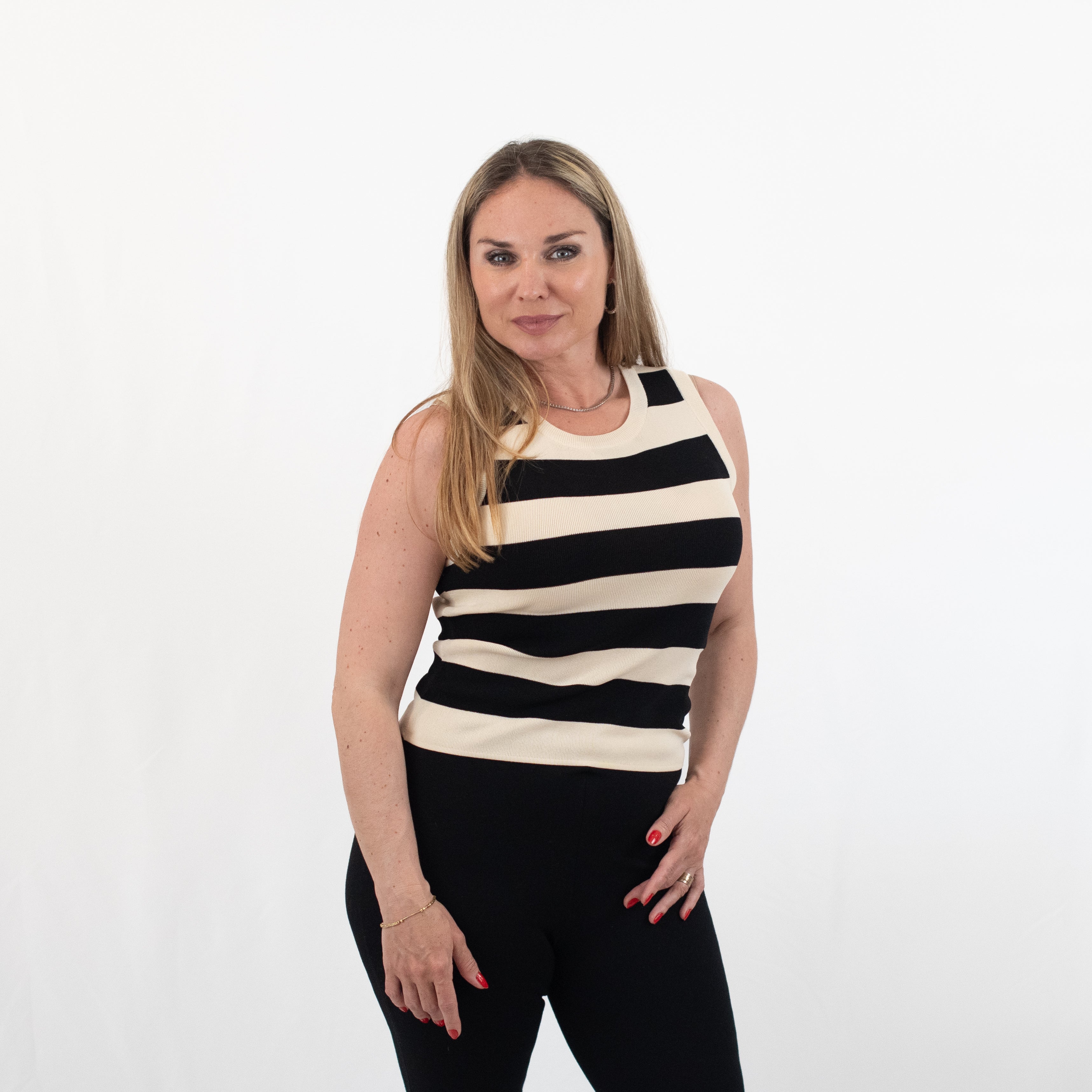 Close-up of a sleeveless black and white striped knit top, highlighting its bold pattern and fitted design.