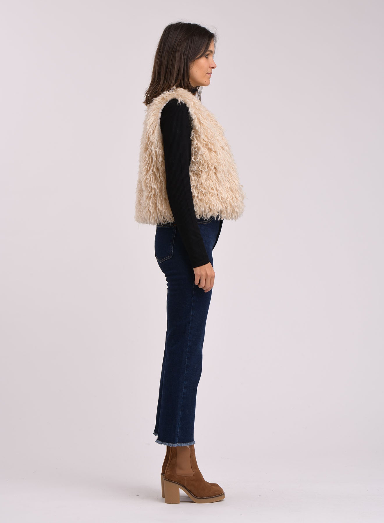 Side profile of the Zoani Faux Shearling Sleeveless Jacket, featuring an open front and cropped fit.