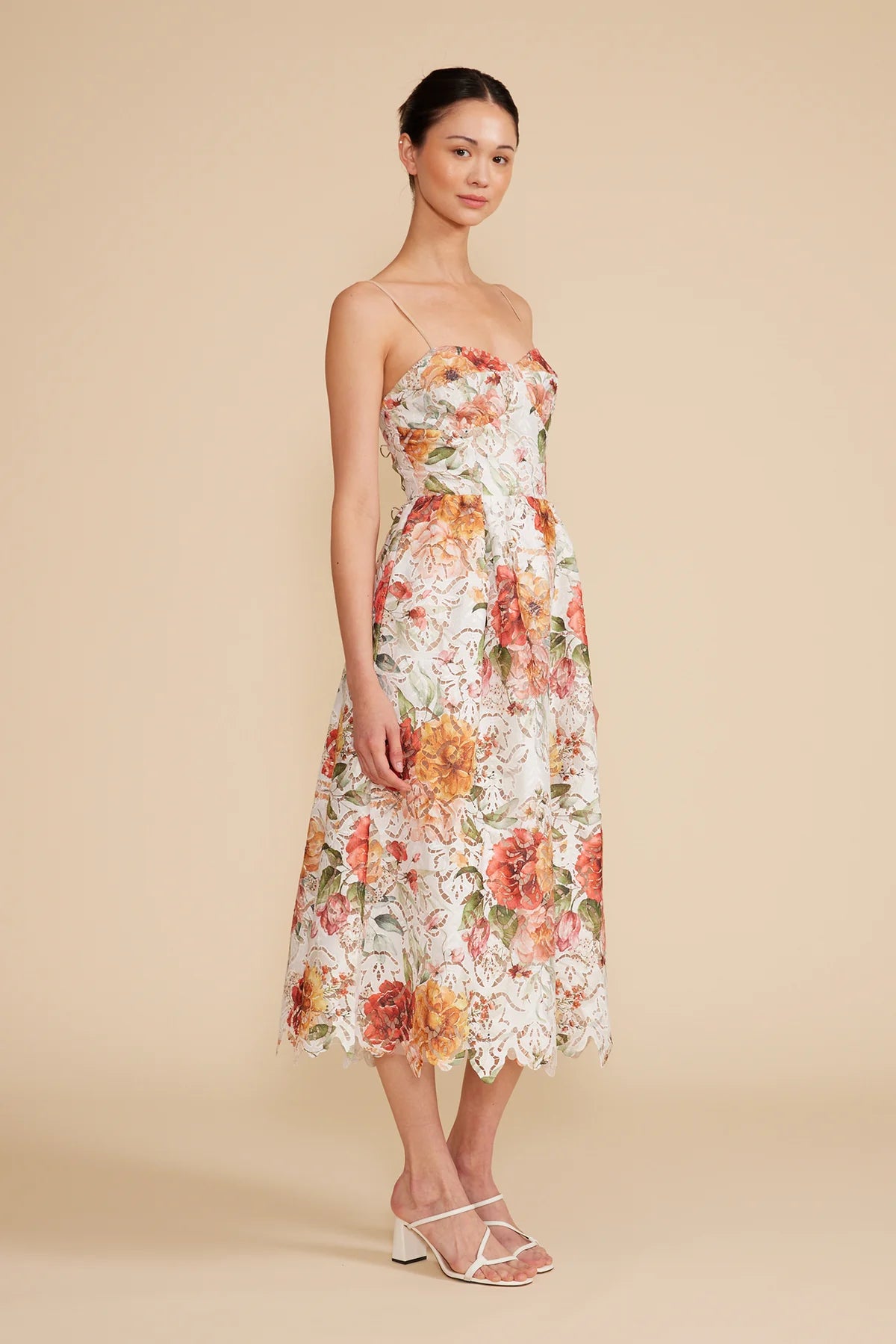 Side view of the woman wearing Mona lace dress, pairing with white sandals.