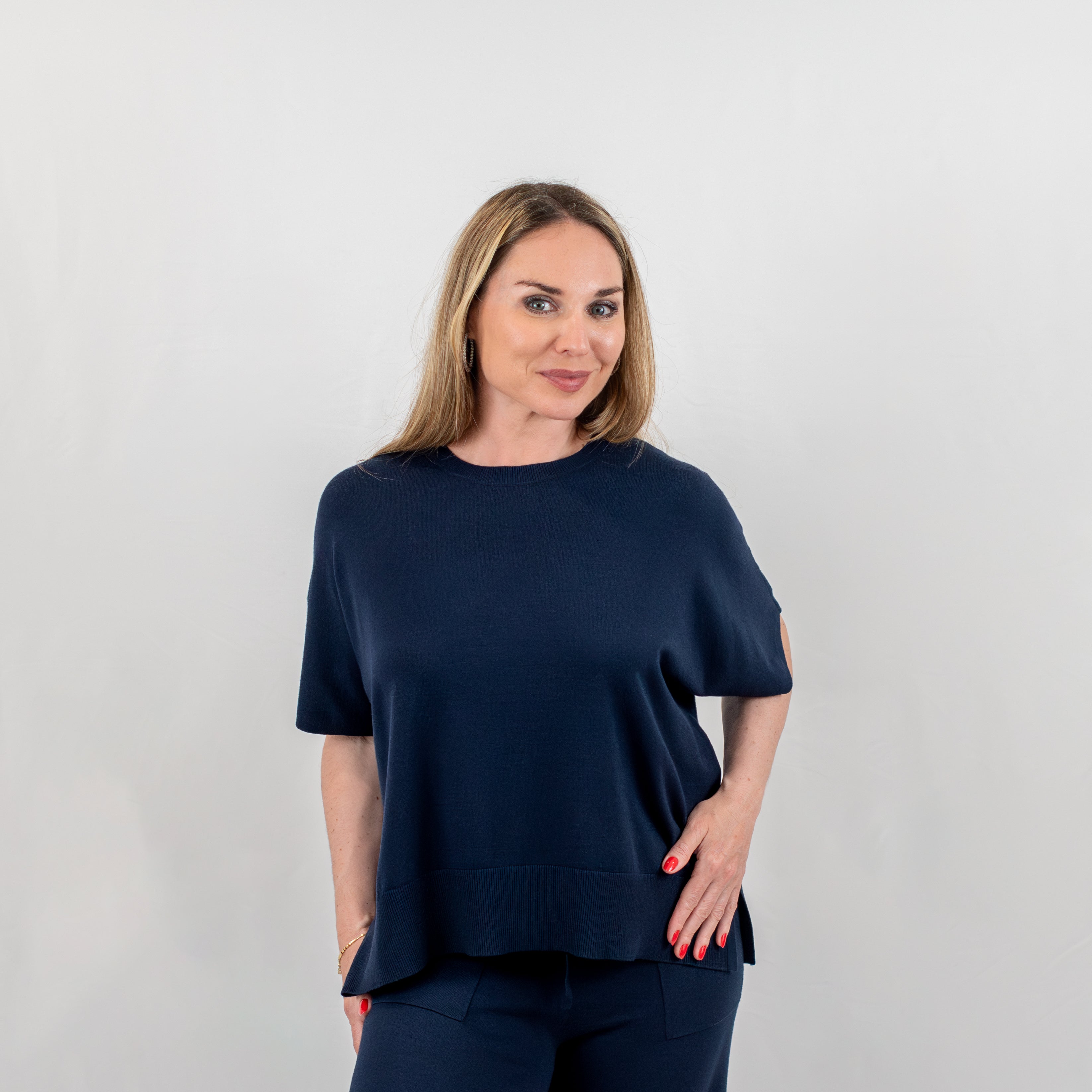 Elegant navy blue women's short sleeve top with a fine knit texture, relaxed fit, crew neck, and ribbed hem detail, ideal for versatile and chic styling.