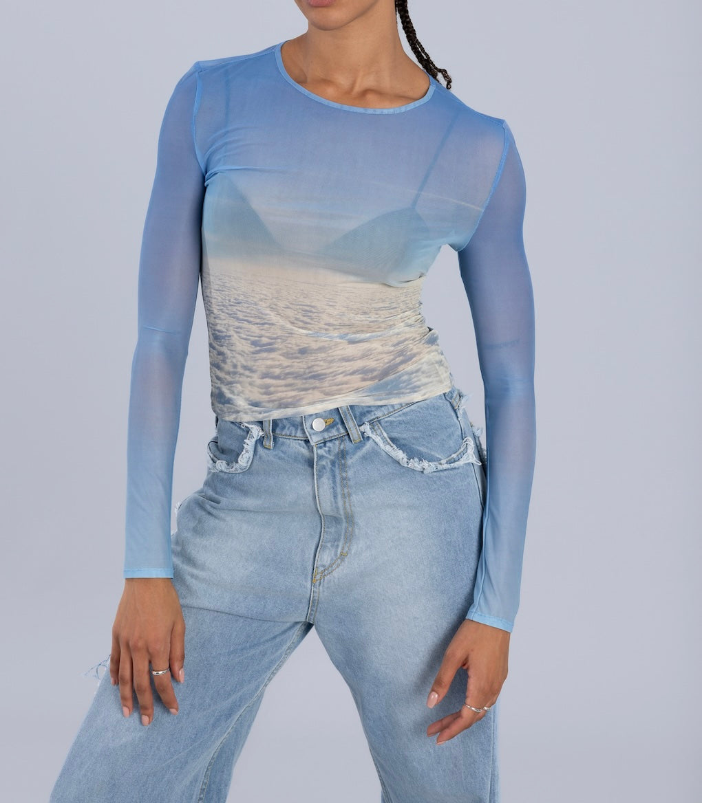 Front view of Oceanic Horizon Mesh Top showing gradient blue to ocean wave print, semi-transparent fabric, and long sleeves with round neckline.