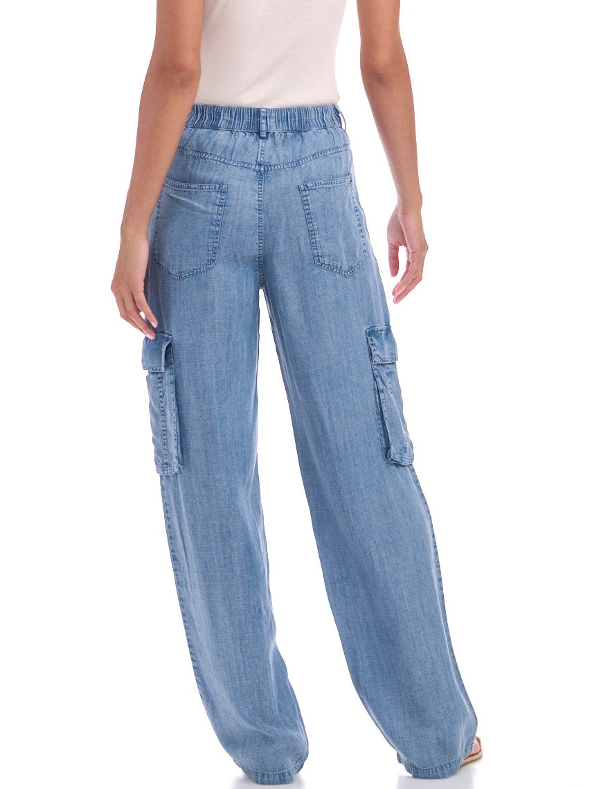 Back view of light-wash wide-leg cargo jeans featuring an elastic waistband, patch pockets, and side cargo pockets, styled casually with a white top.